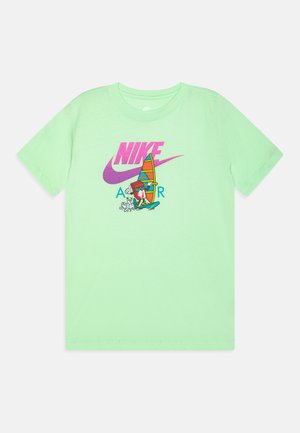 Camiseta de manga corta verde claro hecha de algodón, con un gráfico colorido de un surfista y el logo de Nike en rosa y azul.