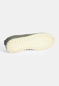 Semelle en caoutchouc avec une surface texturée de couleur crème claire. Tige en daim vert foncé avec un dos arrondi et des détails de couture sur les côtés.