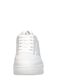 Scarpe sportive bianche con tomaia in pelle liscia, punta rotonda e suola piatta in gomma. Sono visibili i lacci e il logo sulla linguetta.