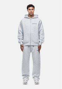 Felpa grigia con zip e pantaloni tuta abbinati realizzati in morbido misto cotone, con accenti del logo nero e una vestibilità rilassata.