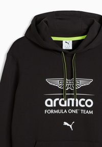 Sweat à capuche noir avec une poche kangourou, des cordons verts, et un marquage blanc incluant le logo Aston Martin et l'inscription "aramco FORMULA ONE TEAM".