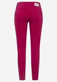 Přeplněné kalhoty v živé fuchsii, vyrobené z hladké bavlněné tkaniny, s pěti kapsami a výraznou etiketou na zadním pásu.