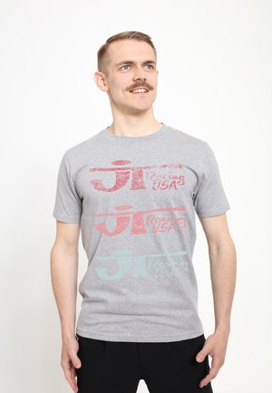 Šedé tričko s krátkým rukávem s opotřebovaným potiskem v červené a tyrkysové barvě, na kterém je napsáno "JT Racing USA" ve třech řadách. Měkký materiál z bavlněné směsi.