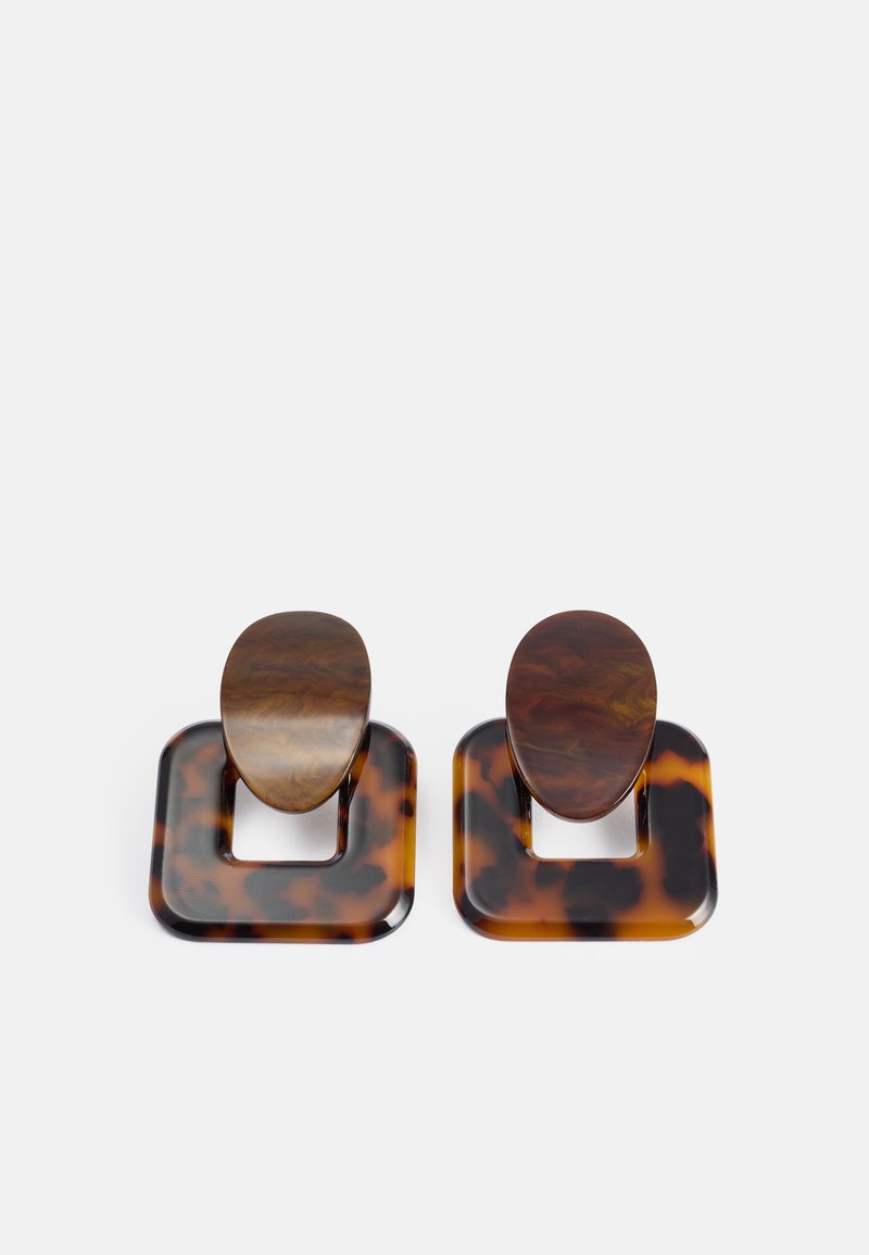 Skjoldmynteøreringer med firkantet basis og oval topp, laget av blank harpiks med en blanding av brune og svarte mønstre.