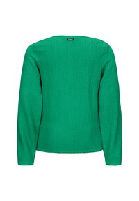 Camicia verde a maniche lunghe con tessuto testurizzato, caratterizzata da un semplice scollo rotondo e un'etichetta sul retro. Nessun hardware o motivo visibile.