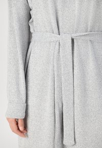 Robe suave cinza em tecido macio com mangas longas, um cinto atado na cintura e uma textura lisa com variação sutil de cor.