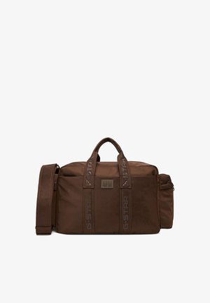 Brązowa prostokątna torba podróżna z dwoma uchwytami, regulowanym paskiem na ramię, boczną kieszenią na zamek oraz paskami z logo G-STAR z przodu.