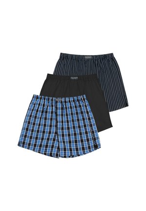 Männlicher Torso trägt blau-schwarz karierte Boxershorts mit elastischem Bund und sichtbarem Markenlabel.