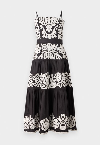 Fekete ruha állítható pántokkal, fehér virágmintázattal és réteges szoknyával. Texturált anyag, amely áramló sziluettet kölcsönöz.