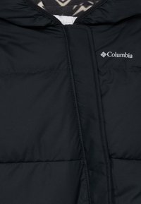 Doudoune noire avec fermeture éclair, dotée d'une capuche et du logo Columbia. L'intérieur présente une doublure à motifs.