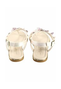 Sandales en cuir blanc avec une finition lisse, accents dorés et ornements floraux en rose et lavande. Sangles réglables au niveau de la cheville incluses.