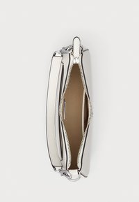 Weiße Lederhandtasche mit Reißverschluss, silbernem Beschlag und abnehmbarem Schulterriemen. Das Innere ist beige und verfügt über eine Tasche.