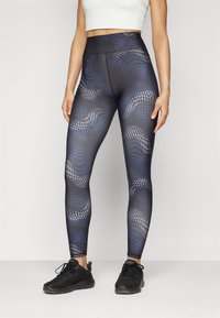 Leggings con un motivo geometrico in nero, blu e grigio, realizzati in materiale elasticizzato con vita alta e una texture liscia.