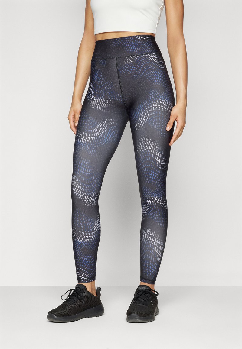 Leggings con un motivo geometrico in nero, blu e grigio, realizzati in materiale elasticizzato con vita alta e una texture liscia.