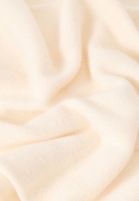 Υφάσμα σε εκρού απόχρωση, μαλακό με ομαλή υφή, που διαθέτει λεπτό πλεκτό σχέδιο και απαλό πέσιμο, ιδανικό για ζεστασιά και άνεση.