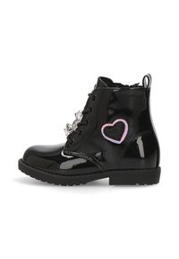 Botín de charol negro con diseño de cordones, que presenta un parche de corazón en rosa y negro y tachuelas decorativas en la parte frontal.