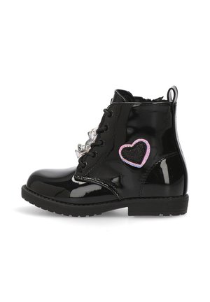 Botín de charol negro con diseño de cordones, que presenta un parche de corazón en rosa y negro y tachuelas decorativas en la parte frontal.