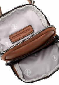 Portafoglio in pelle marrone con doppia cerniera, con una morbida fodera grigia e un'etichetta in pelle personalizzata. L'interno presenta tasche per l'organizzazione.