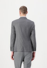Blazer grigio a righe con vestibilità su misura, caratterizzato da un colletto a punte e chiusura a un bottone. Tessuto in lana testurizzato con foderatura a contrasto.