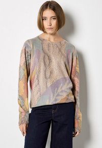 Sweter dzianinowy o mieszanej pastelowej kolorystyce z liściastymi wzorami i szczegółami w plecionkę. Długie rękawy i luźny fason.