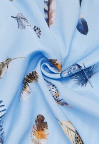 Light blue fabric featuring a feather pattern in various colors, including browns, blues, and creams. Soft, smooth texture with delicate designs.