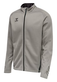 Chaqueta gris de cremallera hecha de tela suave, con un alto cuello, acentos negros y logo. Incluye bolsillos laterales y detalles estampados en las mangas.