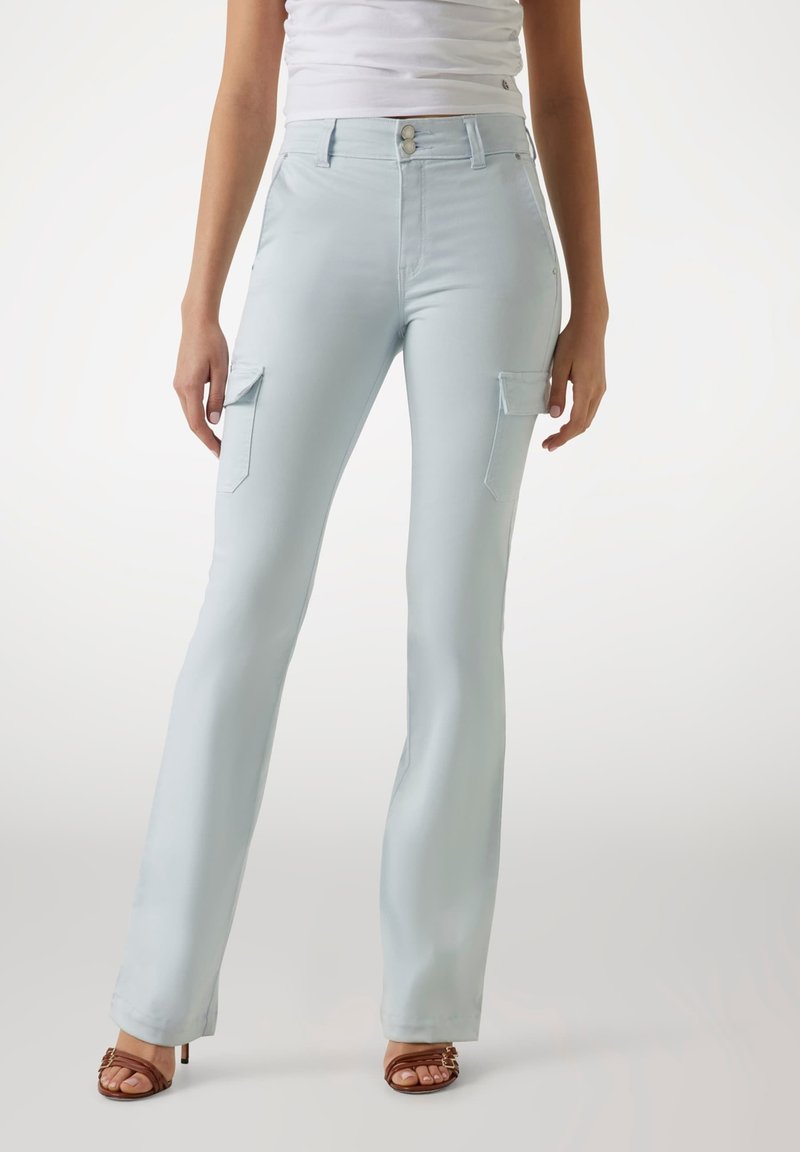Pantaloni a vita alta azzurro chiaro a zampa d'elefante in un tessuto morbido, dotati di due tasche cargo laterali e dettagli in metallo argento sui bottoni.
