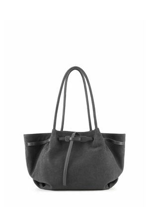 Borsa tote in camoscio nero con doppi manici e dettaglio cinturino sul davanti, in piedi su sfondo bianco.