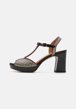 Escarpin à talon haut en noir et tissu à motifs géométriques. Dispose d'un talon épais et d'une sangle de cheville ajustable.