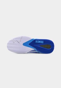 Suela de zapato deportivo K-Swiss azul y blanco con patrón de tracción en zigzag texturizado y amortiguación visible en el área del talón.