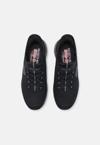 Pantofi slip-on Skechers negri, cu un superior din plasă, șireturi elastice și talpă cu amortizare. Prezintă un logo subtil și accente gri.