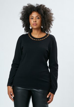 Schwarzer Pullover mit langen Ärmeln und rundem Halsausschnitt, verziert mit einem braunen Perlenakzent, aus weichem Strickmaterial gefertigt.