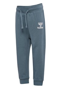 Donkerblauwe joggingbroek gemaakt van zacht materiaal. Voorzien van een elastische tailleband met trekkoorden en een witte logo-detail op de dij.