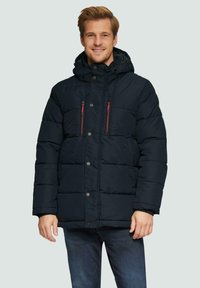 Marineblauwe gewatteerde jas met capuchon, voorzien van rode ritszakken en drukknoopsluitingen. Gelaagd, geïsoleerd ontwerp tot de knie.