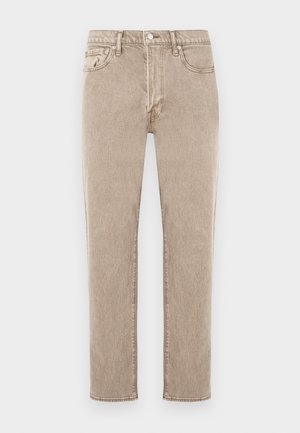 Μπεζ τζιν από τζιν ύφασμα με ίσια γραμμή, διαθέτουν πέντε τσέπες, κλείσιμο με μεταλλικό κουμπί και διακριτική ξεθωριασμένη υφή. Κλασικό στυλ, χωρίς διακοσμητικά στοιχεία.