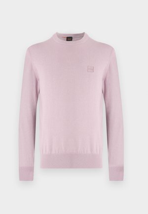 Gaiši rozā džemperis ar apaļu apkakli, garām piedurknēm un nelielu kvadrāta formas logotipa izšuvumu kreisajā krūtīs, attēlots uz vienkārša balta fona.