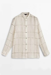 Lett beige skjorte med knaplukning, langærmede og ståkrave. Har et gittermønster og sorte accentlinjer.