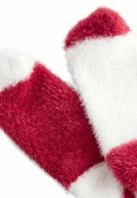 Piros és fehér bolyhos zoknik, amelyek kiemelkedő textúrával rendelkeznek, és kontrasztos színeket tartalmaznak. A tetején egyszínű piros és fehér díszítések találhatók a széleken.