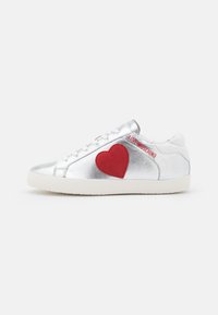Zilverkleurige metallic sneakers met een rood vilten hart aan de zijkant en "LOVE MOSCHINO" in het rood geborduurd. Witte rubberen zool, vetersluiting.