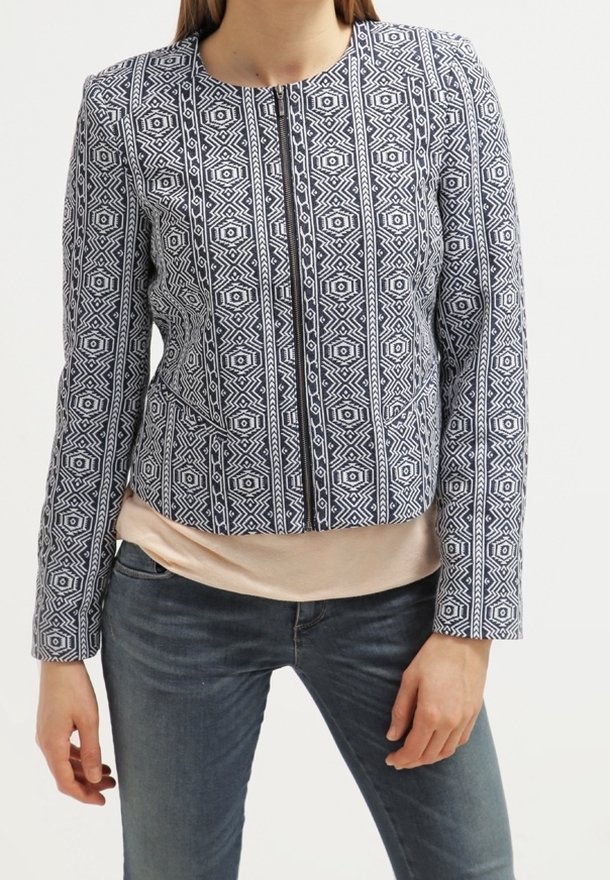 Granatowo-biała kurtka w geometryczny wzór o skróconym kroju, z okrągłym dekoltem, długimi rękawami i bocznymi kieszeniami; wzór geometryczny na teksturowanej tkaninie.