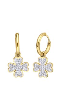 Boucles d'oreilles en or en forme de cercle avec un design de trèfle à quatre feuilles, incrustées de gemmes transparentes, dotées d'une finition brillante et d'une texture lisse.