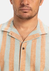Kortebloem shirt in lichtblauw en oranje verticale strepen, met een kraag, een enkele bruine knoop en een gestructureerde stof.