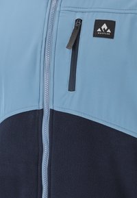 Hellblau- und dunkelmarineblaue Fleecejacke mit vertikalem Reißverschluss und kleiner Brusttasche mit Reißverschluss, die das Logo der Marke Whistler zeigt.