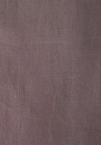 Gros plan sur un tissu doux et texturé de couleur mauve atténuée avec un motif de tissage diagonal subtil.