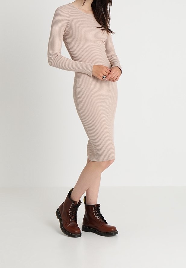 Robe midi côtelée beige à manches longues, associée à des bottines marron à lacets avec semelles épaisses et accents en caoutchouc noir.