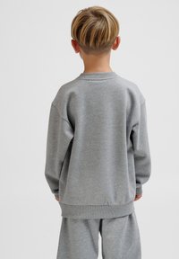Grå sweatshirt med rund hals, oversize passform och ribbad kant. Tillverkad av mjukt material, med en enkel, enfärgad design utan utsmyckningar.