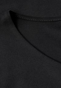 Černé bavlněné tričko s kulatým výstřihem, hladkou texturou a rovnoměrným švem kolem límce a okrajů. 