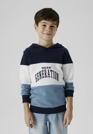 Capuchon sweatshirt met marineblauwe, witte en lichtblauwe kleurblokken. Bevat de tekst "VOICE OF MY GENERATION" in marineblauwe letters. Gemaakt van een katoenmix.