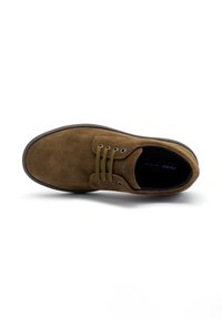 Chaussure en suédine marron avec des lacets vert olive, vue de dessus, mettant en valeur un bout rond et un design minimaliste sur fond blanc.
