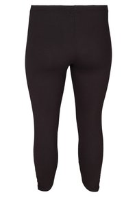 Leggings noirs en tissu extensible, dotés d'un design sans couture, d'une taille élastique et de jambes ajustées avec des accents froncés au niveau des chevilles.